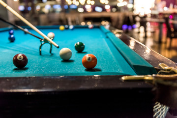 Billiard balls at table and rack for cue