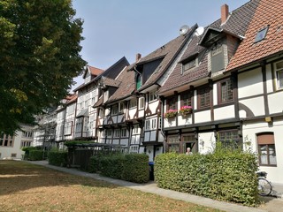 Restaurierte alte Fachwerkhäuser mit grüner Hecke im Sommer bei blauem Himmel und Sonnenschein in...
