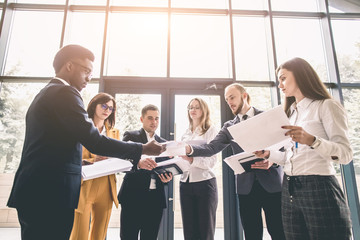 Naklejka premium Team portrait of young and successful business people. Group of young businessmen and businesswomen discussing in modern office