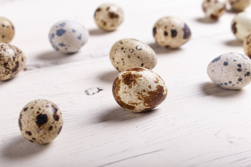 quail eggs on a white wooden background.