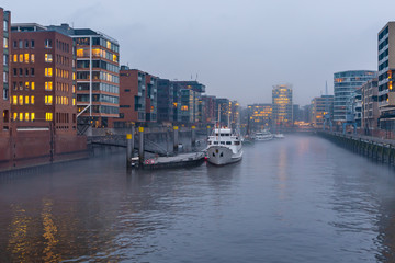 The Harbor District (HafenCity) in Hamburg, Germany, on a foggy day. View of the Sandtorkai and the Kaiserkai across the traditional port (German: Traditionsschiffhafen or Sandtorhafen).
