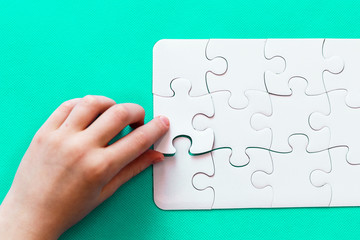 Jigsaw Puzzle with missing piece on mint background People hand