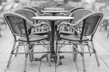 Rattan chairs and tables of a coffee house in Hamburg, Germany. Black and white photography.