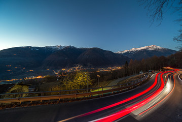 Lightstrails of vehicles in movement for a road in the moonlight Motta, Italy.