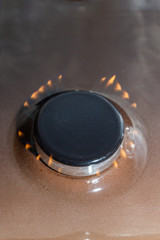 Gas stove with burning orange and blue fire on it