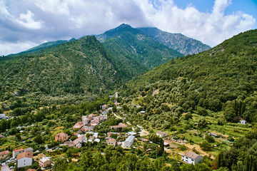 Fototapeta na wymiar Aerial view of green surroundings of Corte town in Corsica with mountains in background