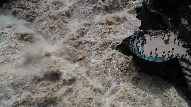 Static drone shot of tourists taking photos of Tiger Leaping Gorge in China