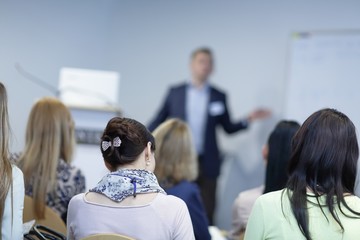 background image of a businessman speaking at a business seminar.