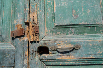 Old colorful paint peeling on a vintage rustic wooden door