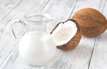 Jug of coconut milk with fresh coconut