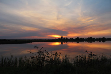 Colorful sky and colorful water in lake reflected in evening. Russia.