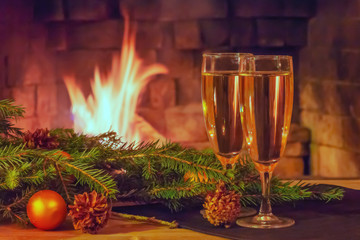 Two glasses of champagne, decorations, Christmas tree branches and a candle on a wooden table in front of a burning fireplace