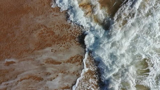 Top view aerial Atlantic coastline in Portugal Portimao beach waves reaching sand shore