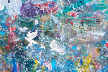 close up the colorful water color art and abstract on top of a child table covered in paint splatter