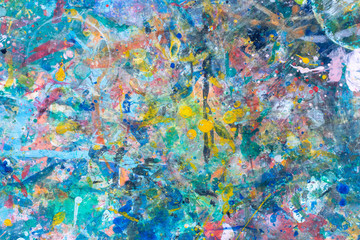 close up the colorful water color art and abstract on top of a child table covered in paint splatter