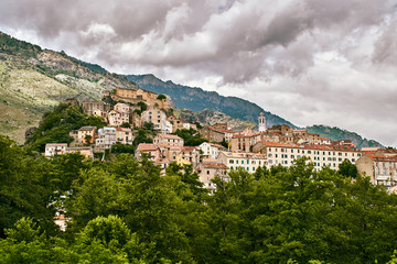 Fototapeta na wymiar Panoramic view of Corte city in Corsica with dramatic sky clouds