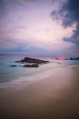 Fototapeta na wymiar Sunrise at Bintan Island. Sand sea sky clouds and stones