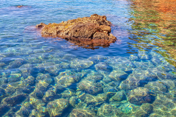 transparent sea water and stones on the bottom