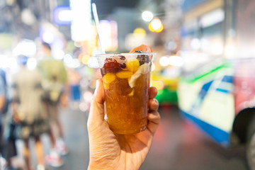 Modern chinese dessert on hand holding with China town blurry background, Bangkok Thailand.