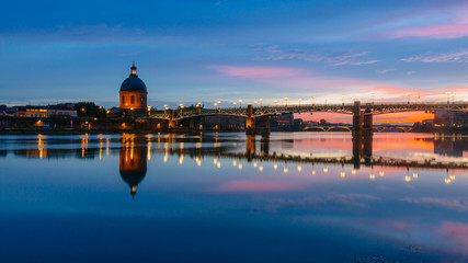 Sunset over Garonne River, with reflections of Saint-Pierre Bridge and Chapel of hôpital Saint-Joseph de la Grave, in Toulouse, France - obrazy, fototapety, plakaty