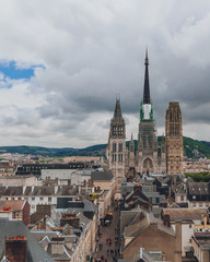 Obraz premium Towers and front façade of the Rouen Cathedral over medieval street and buildings of the city center of Rouen, France