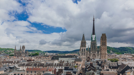 Fototapeta na wymiar Towers and front façade of the Rouen Cathedral over medieval street and buildings of the city center of Rouen, France
