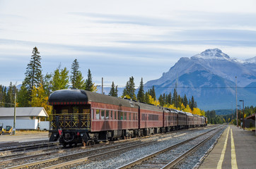 秋のカナディアンロッキー　黄葉のバンフ駅に停まる旧式の列車とカスケード山（バンフ国立公園　カナダ・アルバータ州）