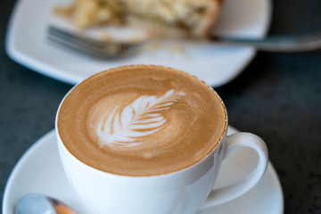 Cup of latte coffee with cake, close up