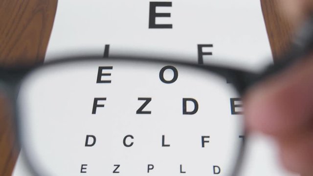 Enlarged letters of chart. The lenses of the glasses on the Snellen table.