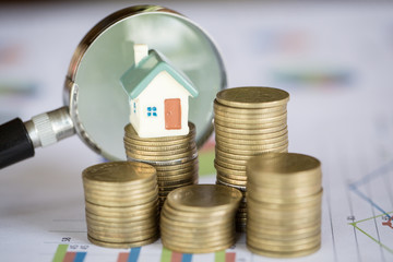 Stack coin and bar graph with grow,  magnifying glass searching for a new home, Loan for real...