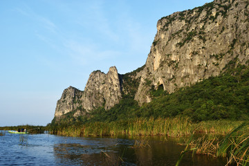 Fototapeta na wymiar Rock cliff and green forest on limestone mountain on the vast wetland at Khao Sam Roi Yot National Park , Thailand 