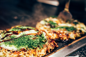 cooking okonomiyaki in local restaurant
