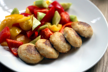 Macro photo of delicious pike burgers with vegetables on a white plate