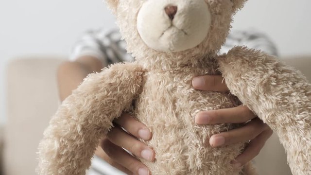 hand of asian girl holding a teddy bear and send it a gift