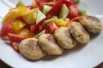 Macro photo of delicious pike burgers with vegetables on a white plate