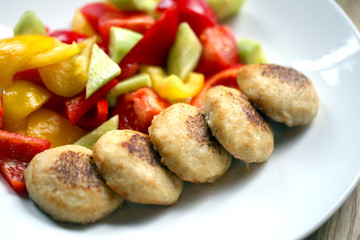 Macro photo of delicious pike burgers with vegetables on a white plate
