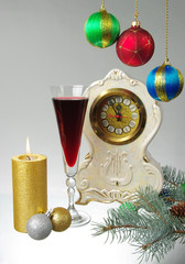 Glass of red wine, clock and burning candle