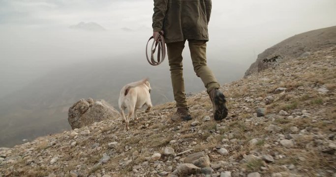 Senior caucasian man walking in fogged mountains with his positive retriever dog - old friendship concept 4k