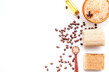 Aromatherapy and spa concept. Spa salt with coffee scent near soap, spa oil and loofah on white...
