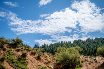 Fototapeta na wymiar Landscape photo of rain water erosion landcape with blue cloudy sky