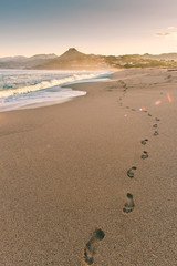Fresh footprints in a sand on beautiful beach in Corsica on beautiful sunny morning
