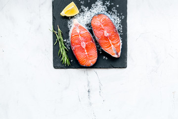 Fresh salmon steak with rosemary, lemon for cooking healthy food on marble background top view mock-up