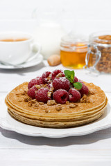 traditional pancakes with fresh raspberries for breakfast on wooden table, vertical