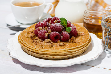 traditional sweet pancakes with fresh raspberries for breakfast on wooden table