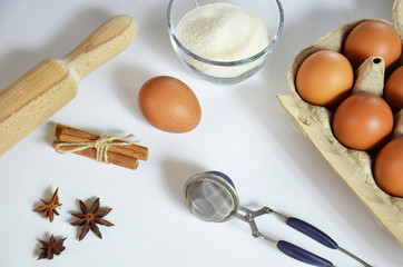 Fototapeta na wymiar Egg, cinnamon, honey, almond flour, flax seeds, vanilla extract, salt. Ingredients for bread muffins. rolling pin, star of anis on the white background