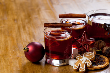 Mulled wine with ingredients on wooden background, top view.