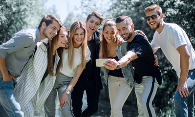 group of friends takes a selfie on the background of the city Park