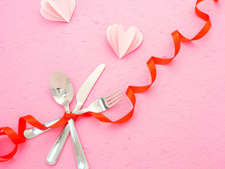 cutlery and hearts on pink table