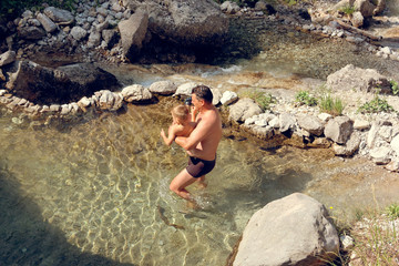 people bathes in a mountain stream a waterfall on stones in nature.