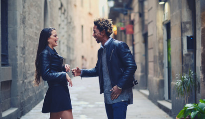 Una pareja feliz y enamorada interracial en las calles de Barcelona pasando un día bonito.